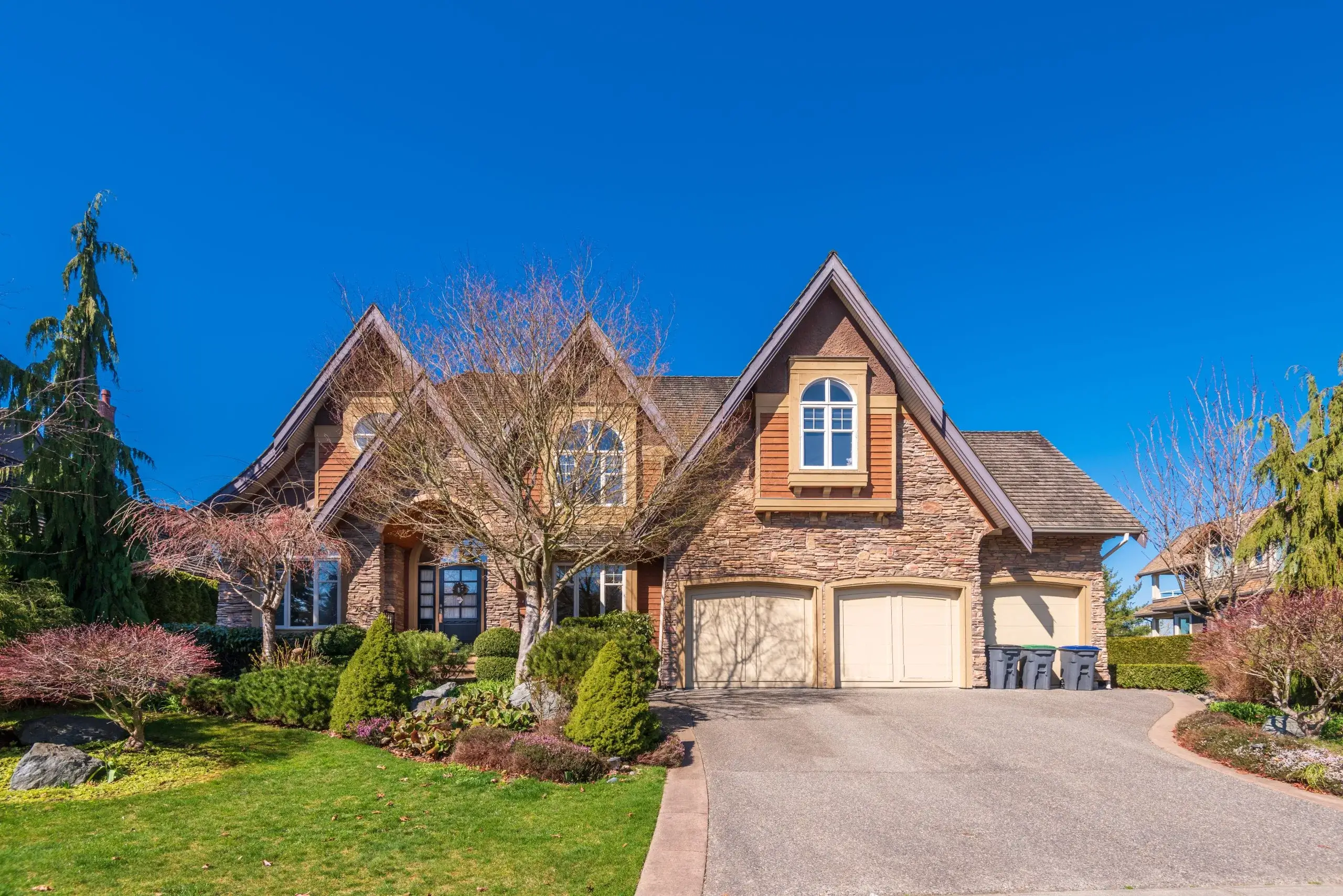 A charming, large house with a well-maintained lawn and blue sky backdrop