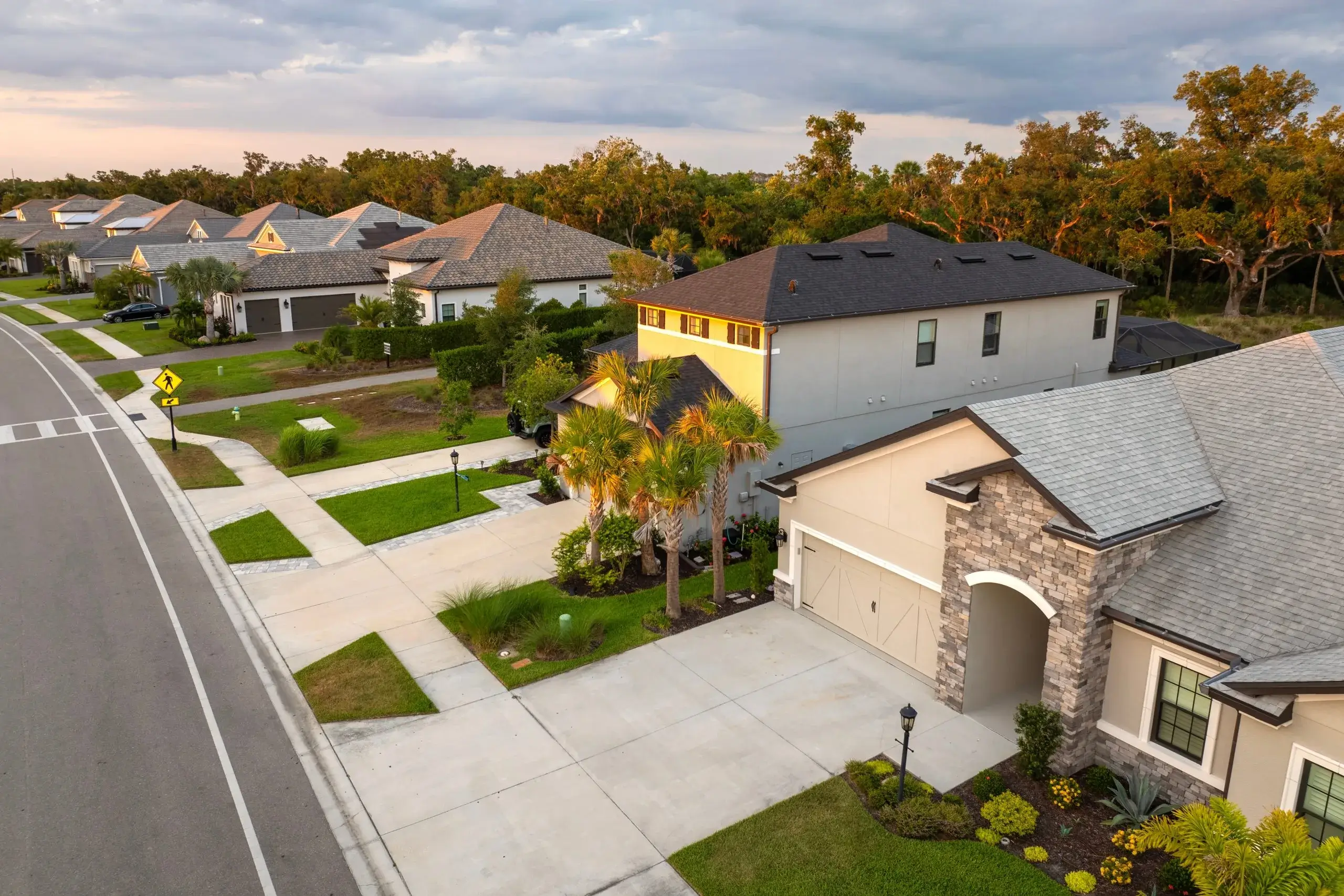 A tranquil suburban neighborhood features houses with well-maintained lawns and winding roads